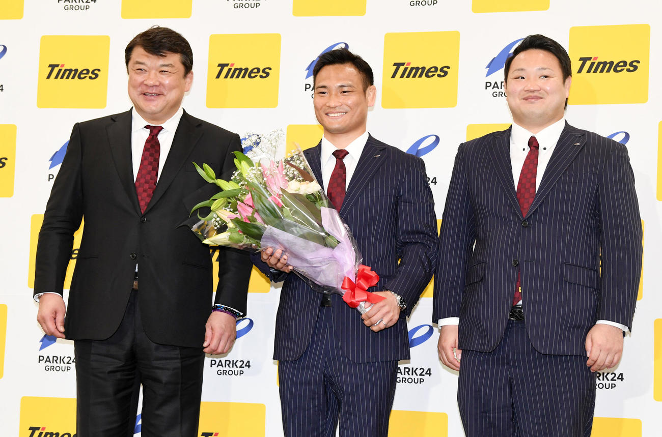 花束を手に笑顔を見せる海老沼匡（中央）。左は吉田総監督、右は兄の海老沼聖監督（撮影・横山健太）