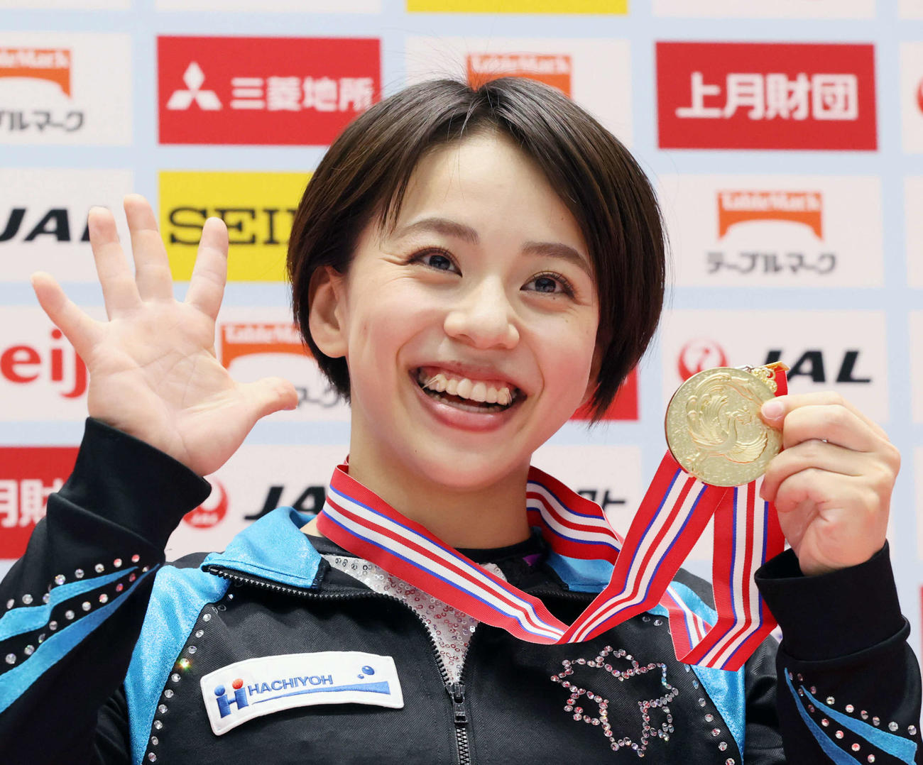 女子個人総合で5回目の優勝を果たし、「5」を手で表す笑顔の村上茉愛（代表撮影）