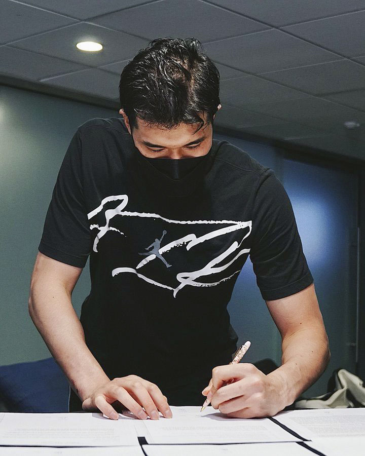 NBAラプターズの公式ツイッターにアップされた書類にサインする渡辺雄太の写真（ラプターズ提供）（共同）