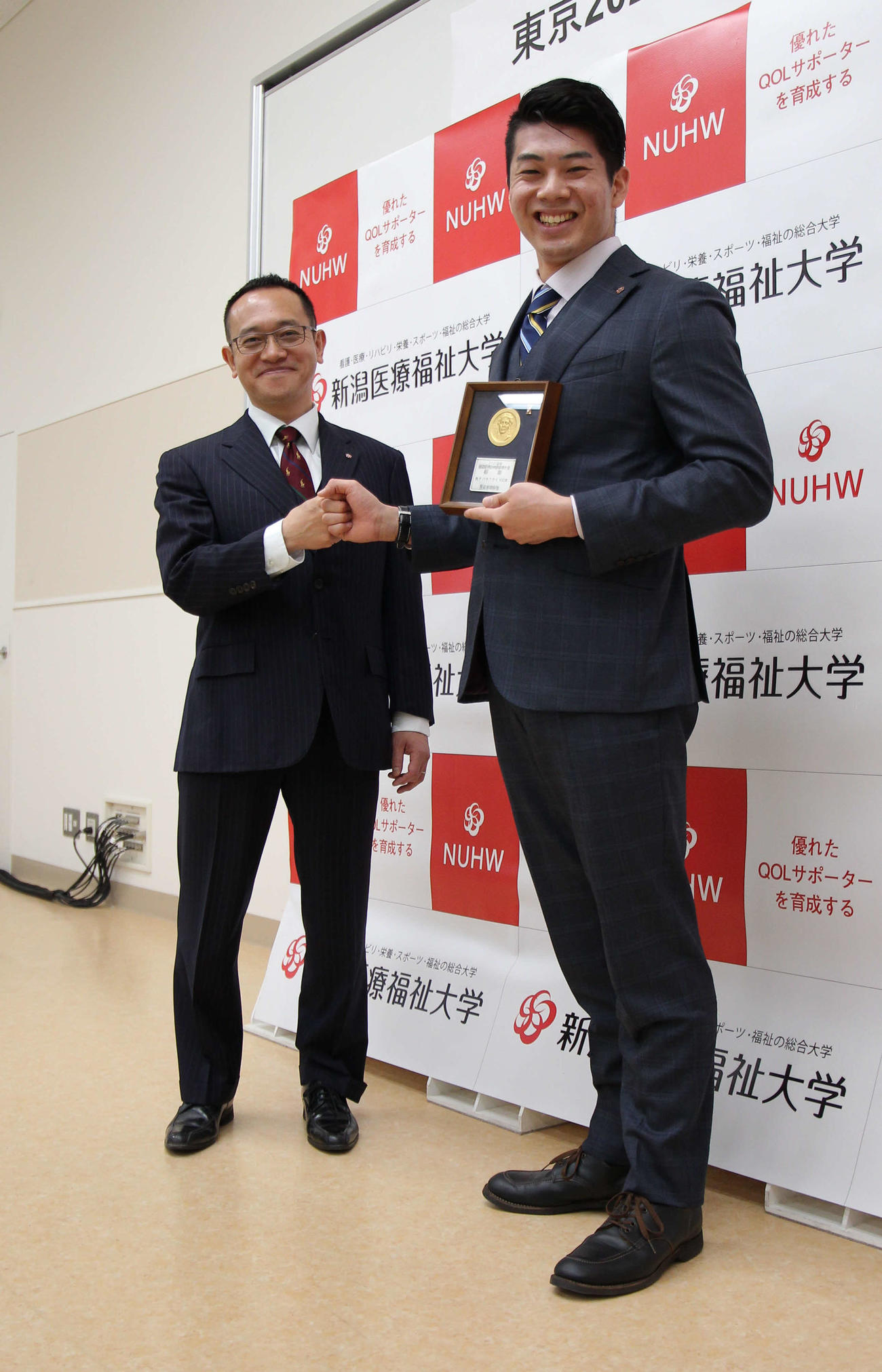日本代表コーチの下山監督（左）と笑顔でグータッチする水沼