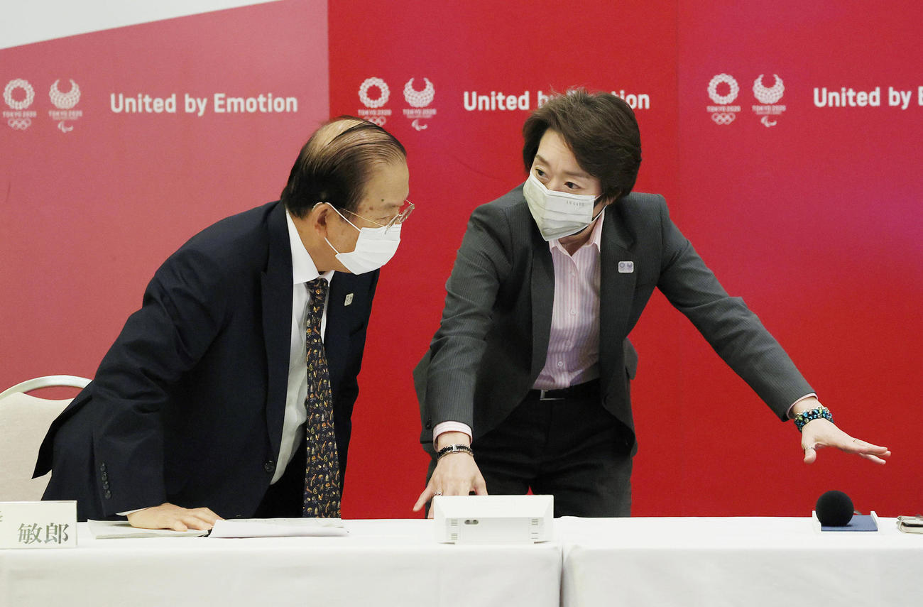 東京五輪・パラリンピック組織委員会の理事会前、言葉を交わす橋本会長（右）と武藤事務総長（代表撮影）