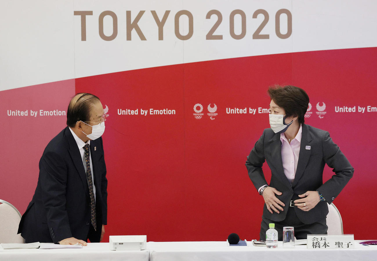 東京五輪・パラリンピック組織委員会の理事会を前に、言葉を交わす橋本会長（右）と武藤事務総長（代表撮影）