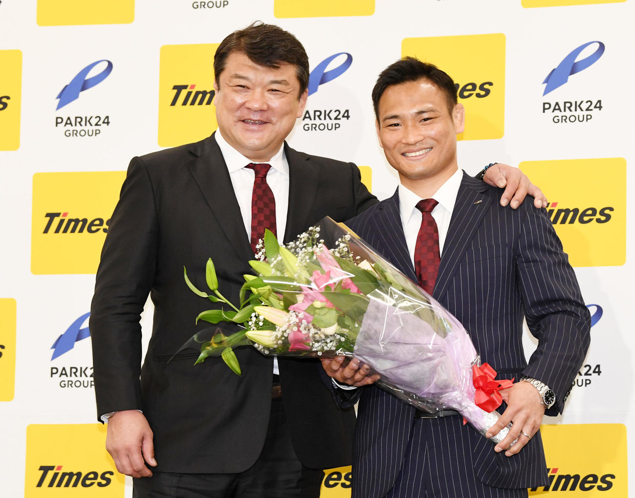 15日、花束を手に笑顔を見せる海老沼。左は吉田総監督