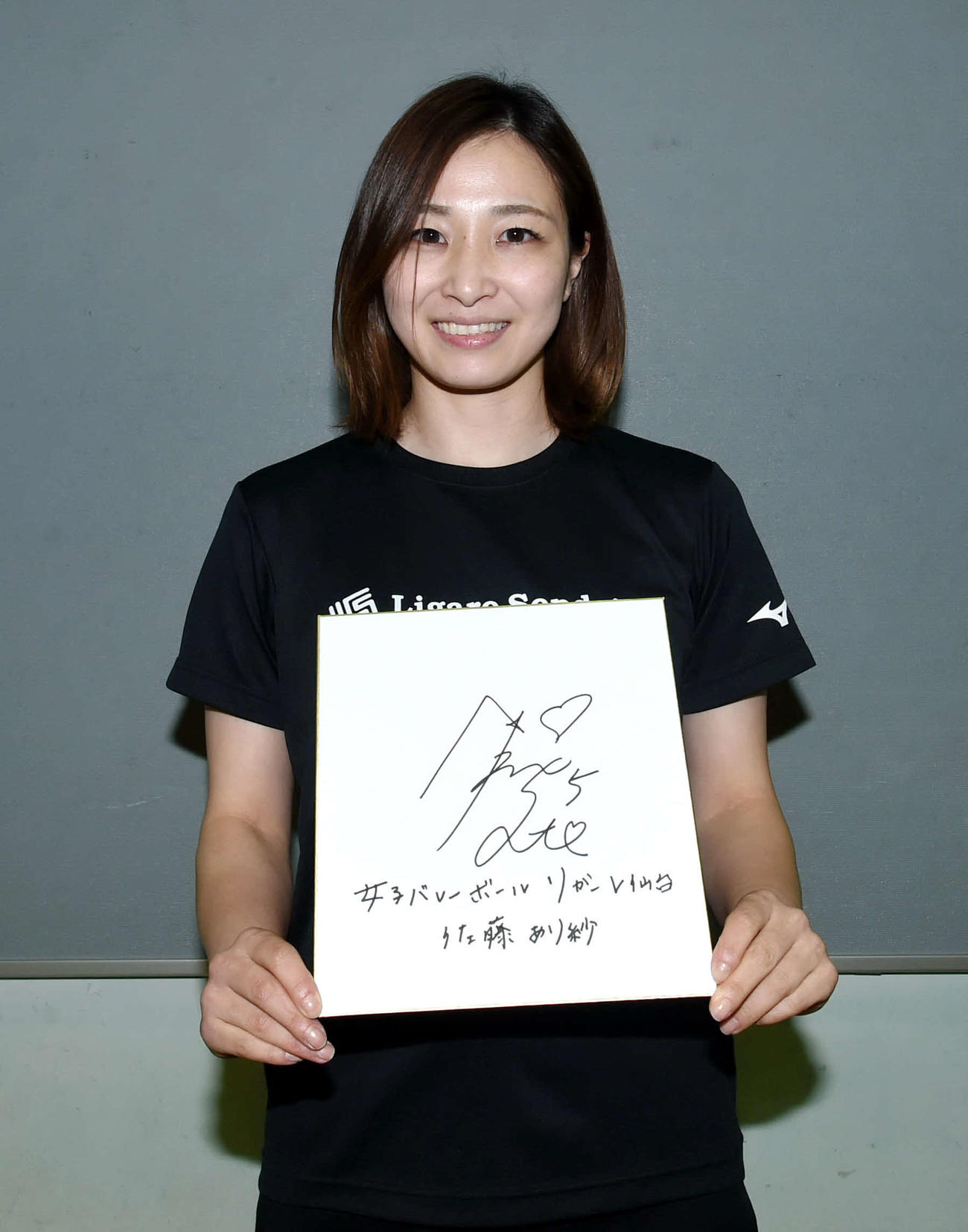 サイン色紙を手にする佐藤