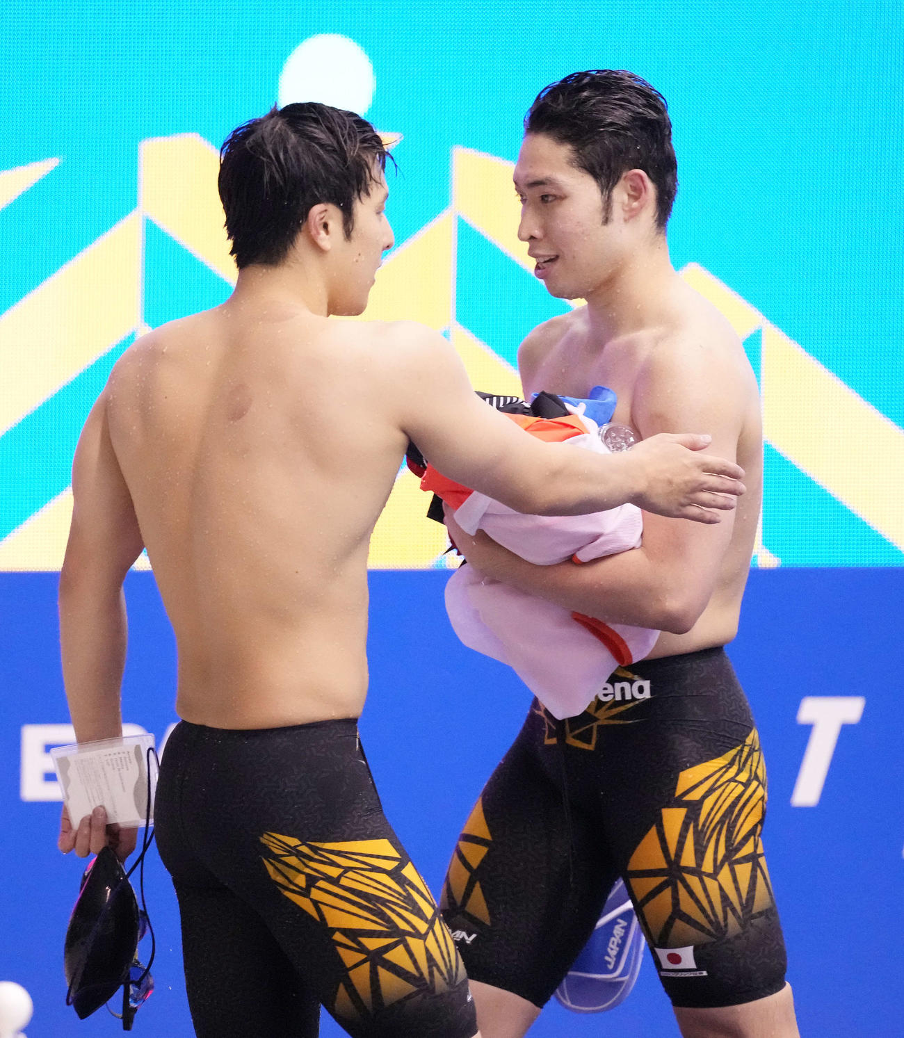 男子200メートル個人メドレーで5位の萩野（右）は3位の瀬戸から労われる（撮影・鈴木みどり）