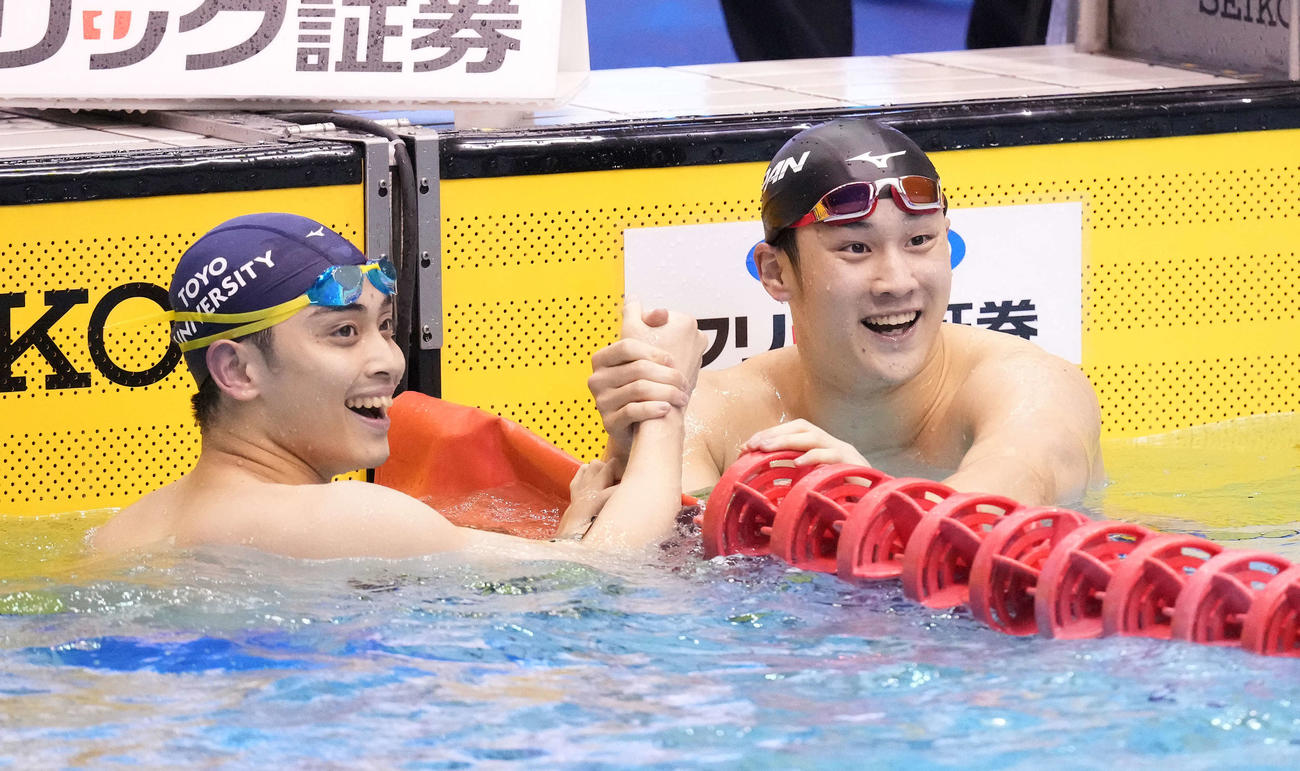 男子200メートル平泳ぎで優勝した佐藤（右）は2位花車とタッチを交わす（撮影・鈴木みどり）
