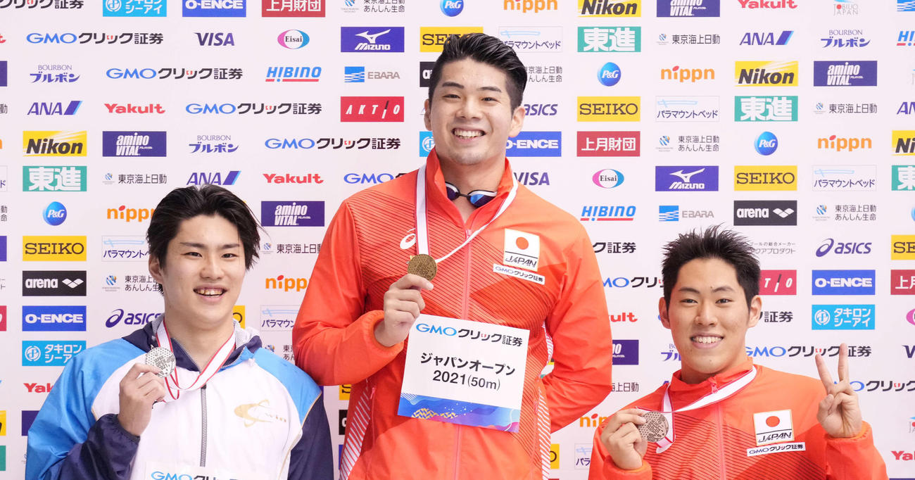 男子100メートルバタフライで優勝し表彰台で笑顔の水沼（中央）。左は2位の赤羽根、右は3位の本多（撮影・鈴木みどり）