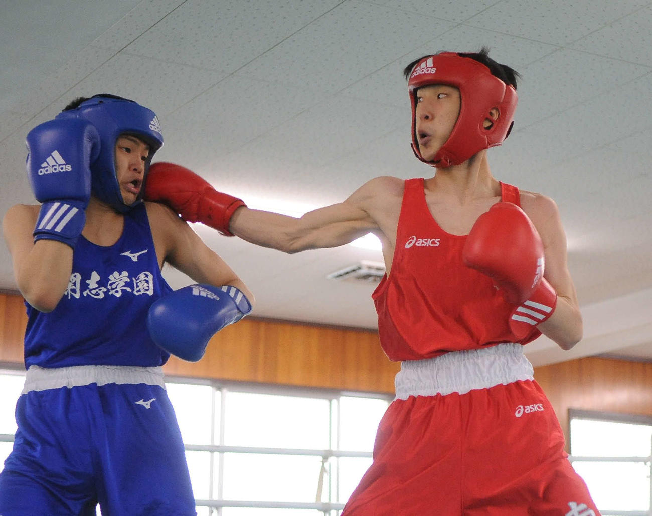 フライ級決勝　開志学園・寺島（左）に右をヒットさせる新潟南・佐野