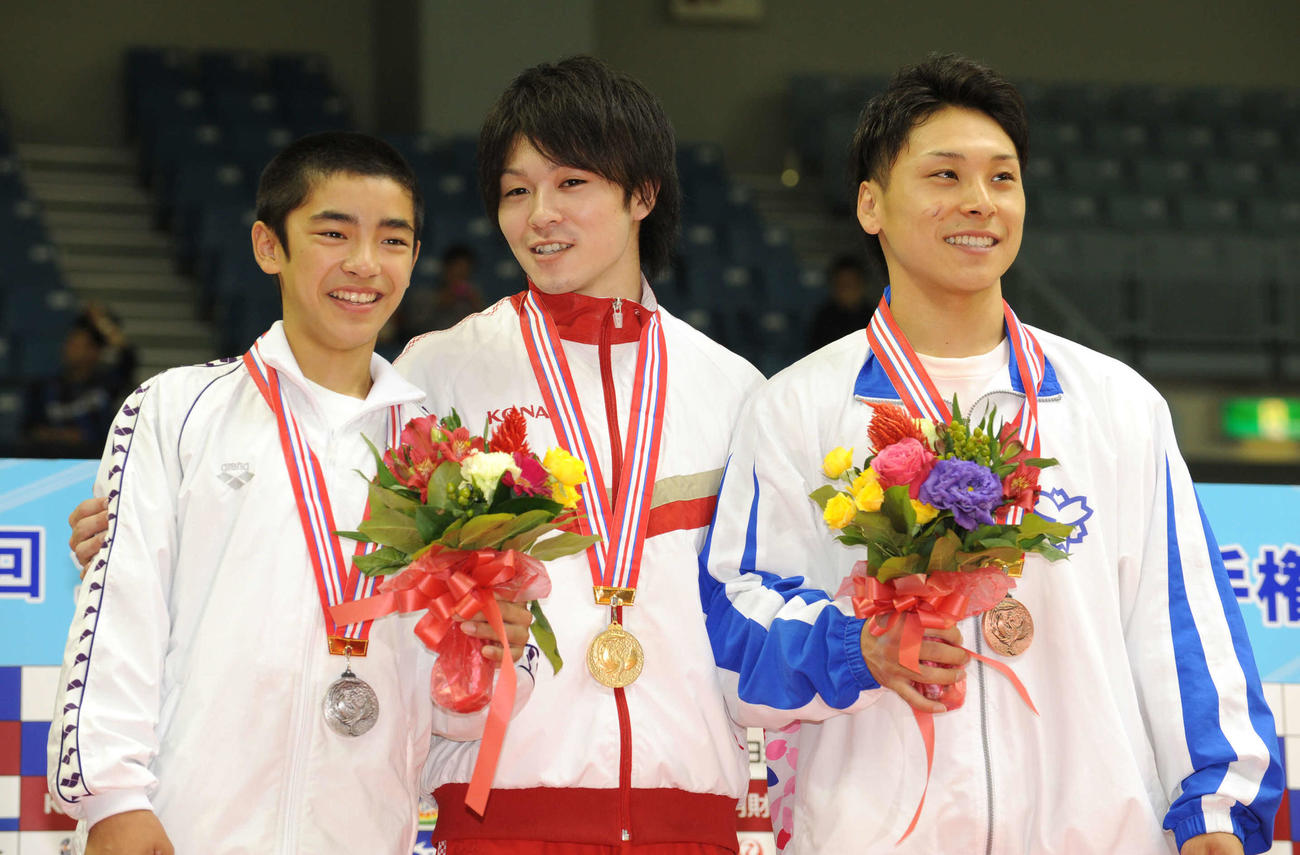 全日本体操種目別の男子床の表彰に臨む、左から2位の白井、優勝の内村、3位の佐藤（2011年11月6日撮影）