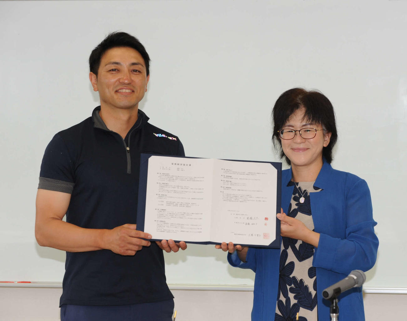 協定書を手にする遠藤さん（左）と大箸会長