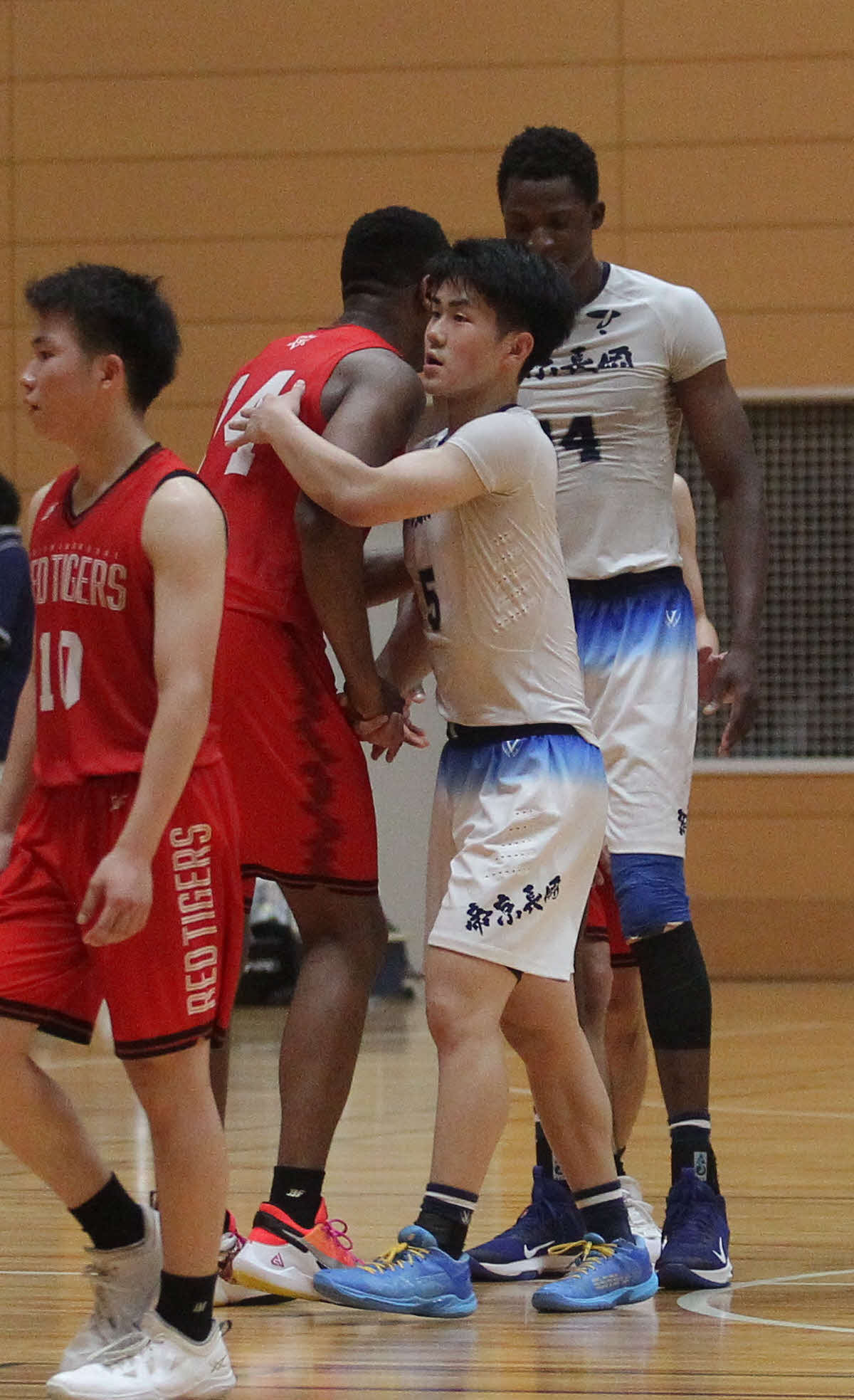 帝京長岡対開志国際　決勝終了後、相手の健闘をたたえて握手する帝京長岡・古川（中央）
