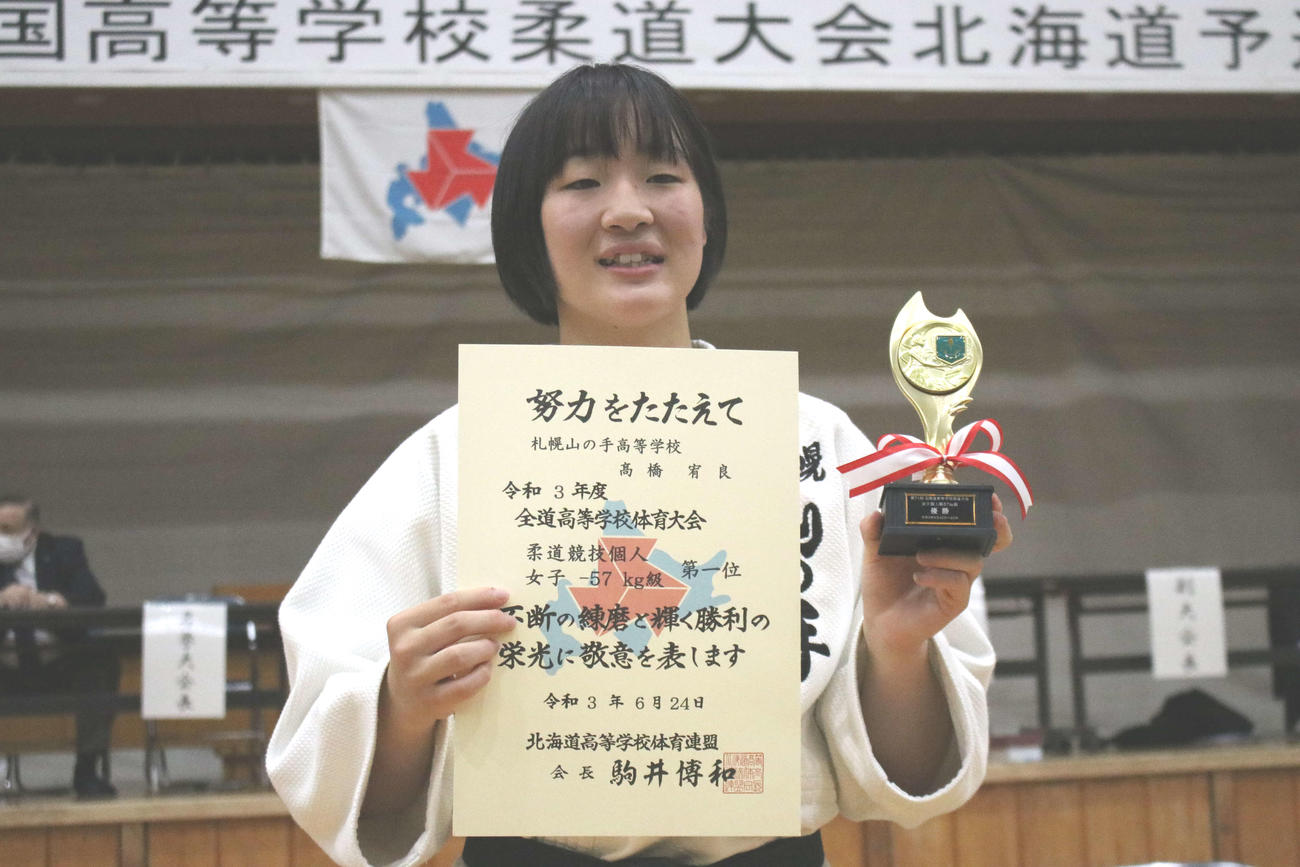 女子個人57キロ級優勝の高橋宥は笑顔で賞状とトロフィーを掲げる（撮影・小林憲治）
