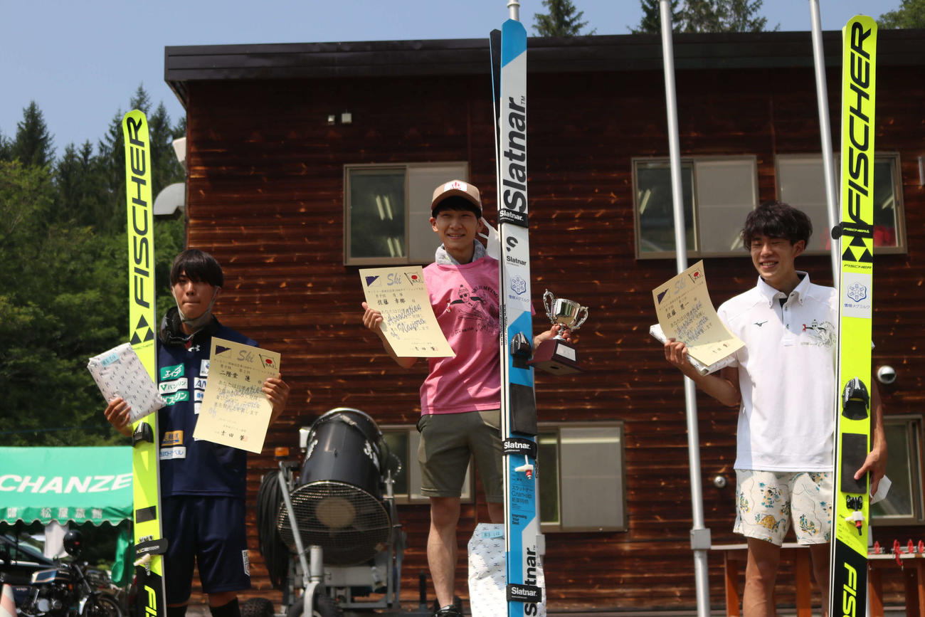 男子個人で優勝しカップを持つ佐藤幸（中央）。左は2位二階堂、右は3位佐藤慧（撮影・小林憲治）