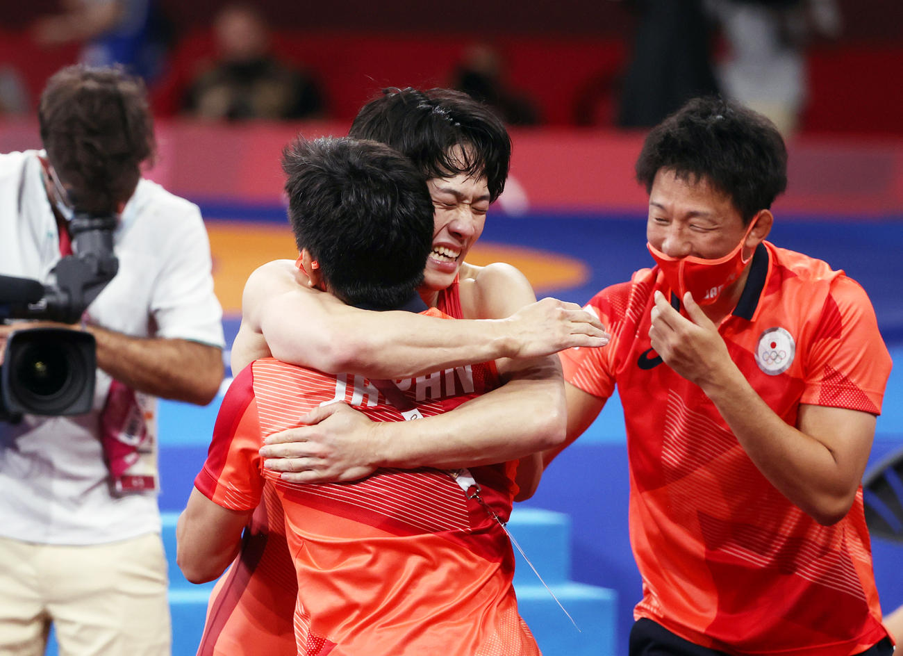 男子フリースタイル65キロ級決勝を制しコーチと抱き合う乙黒拓（中央）（撮影・パオロ・ヌッチ）