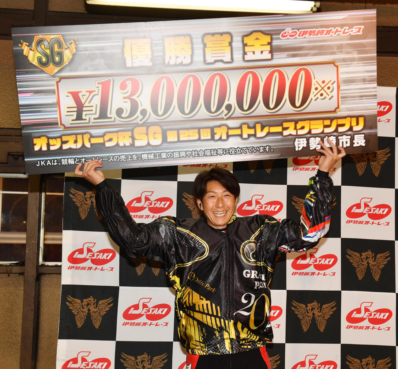 優勝の賞金ボードを掲げる篠原睦（撮影・柴田隆二）