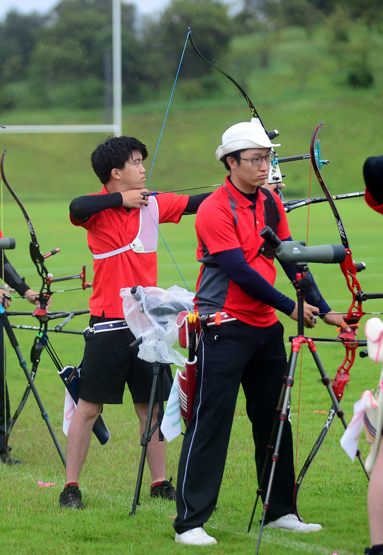 東京五輪代表の武藤（手前）と並んで弓を放つ成年男子の辻