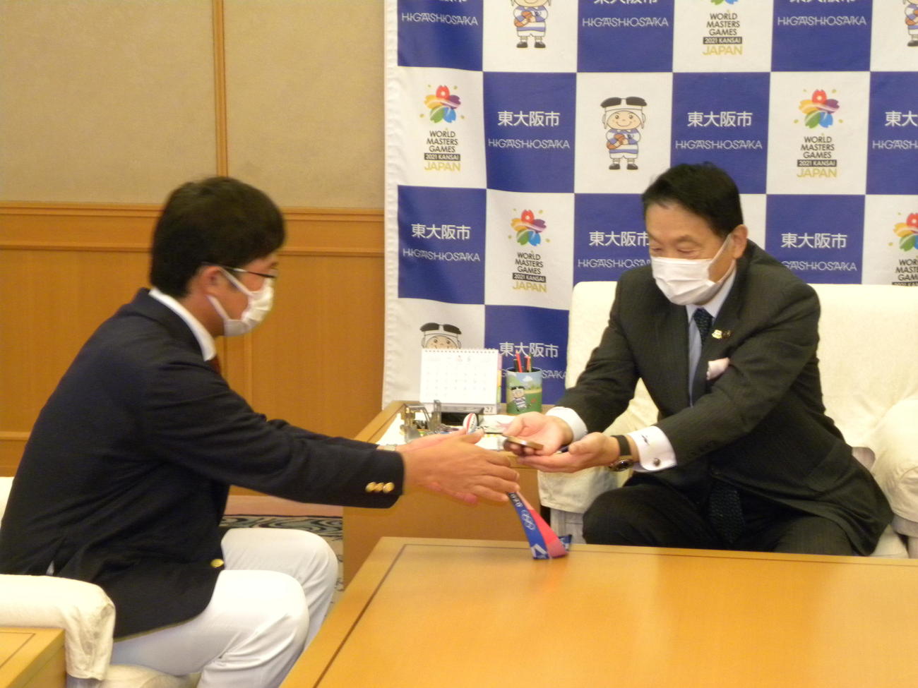 東大阪市の野田義和市長（右）に銅メダルを手渡すアーチェリーの古川高晴（撮影・松本航）