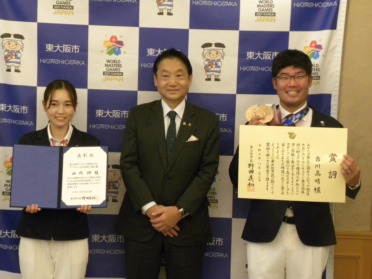 東大阪市の野田義和市長（中央）から市長賞詞を授与されたアーチェリーの古川高晴（右）とスポーツ表彰を受けた山内梓（撮影・松本航）
