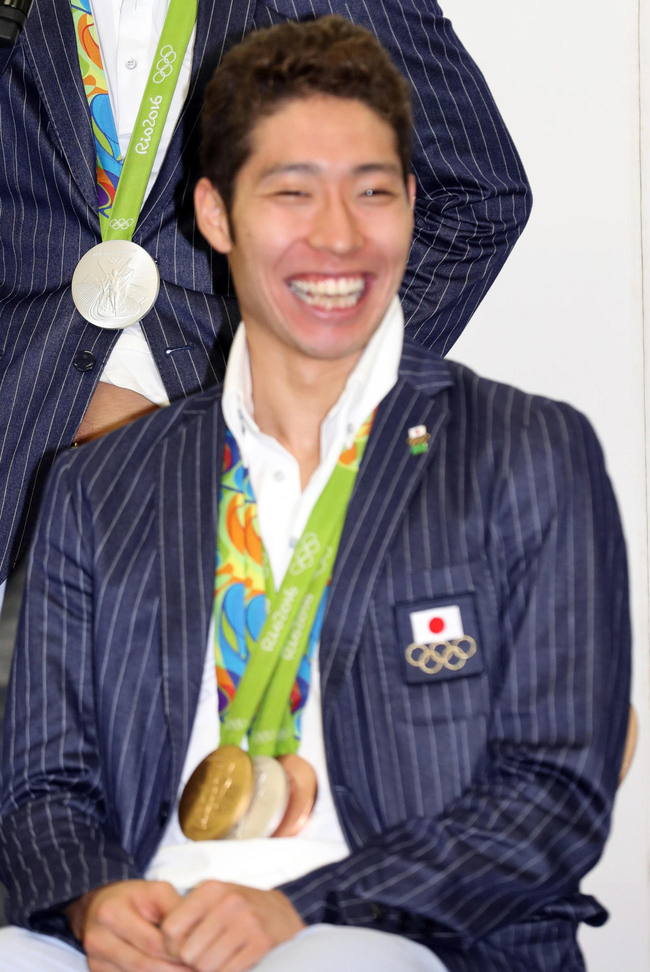 リオ五輪からの帰国会見でメダルを胸に笑顔の萩野＝2016年8月