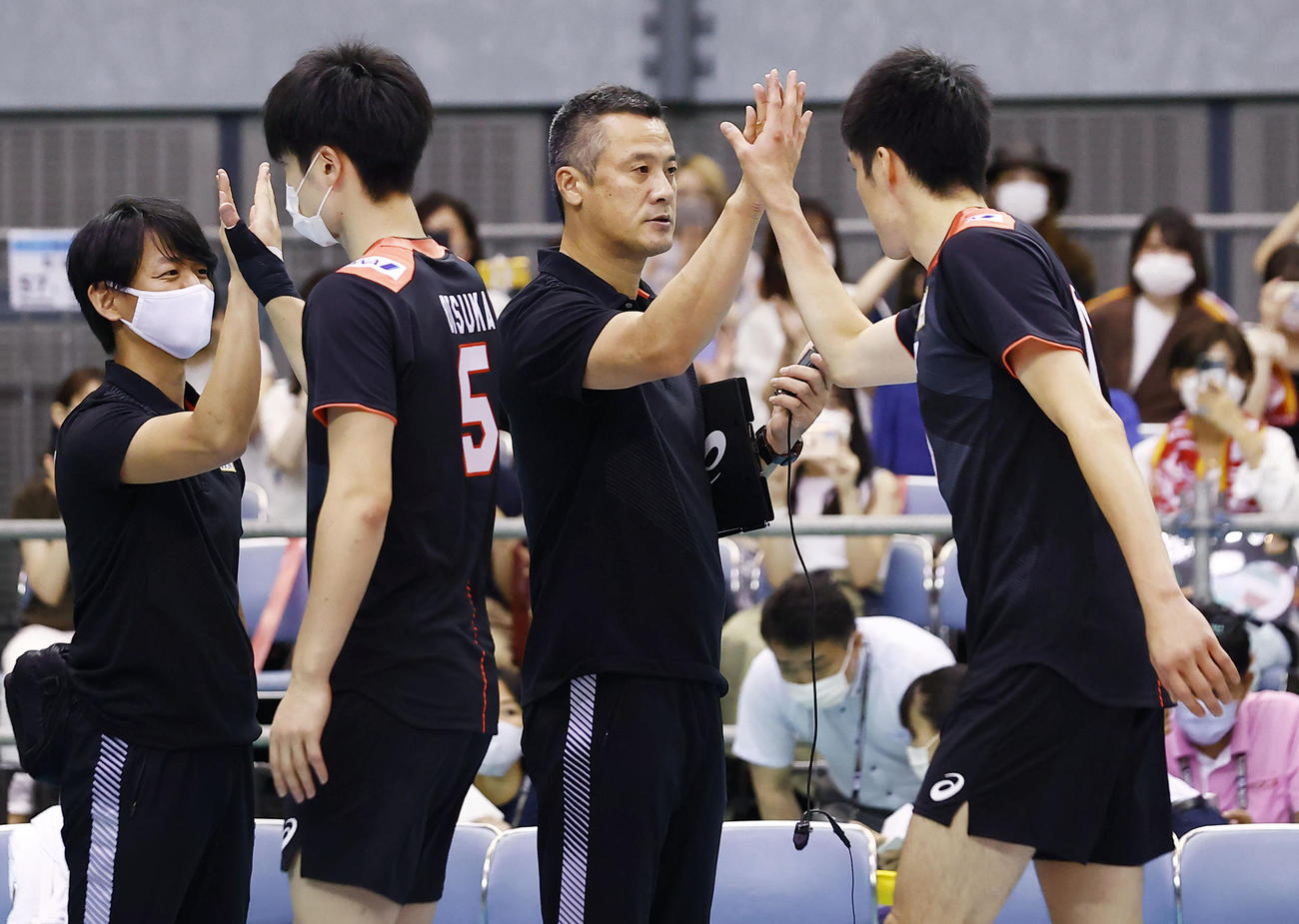 バーレーンに勝利し、選手とタッチを交わす中垣内監督（右から2人目）（共同）