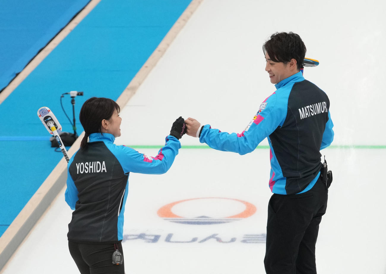 竹田智子、竹田直将組との対戦の第5エンドを終え、笑顔でタッチを交わす吉田夕梨花（左）、松村雄太組（代表撮影）