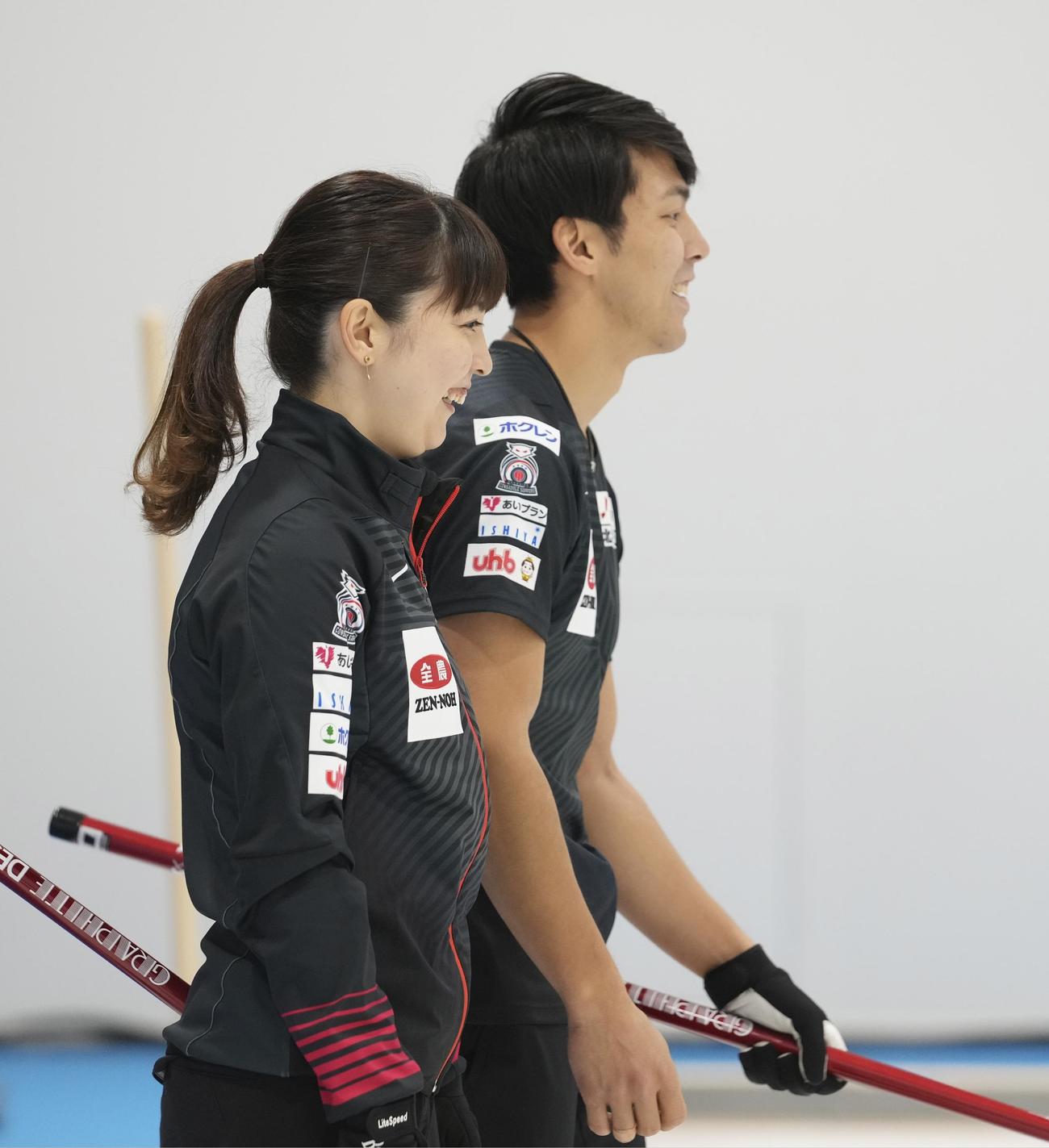 カーリング混合ダブルス日本代表決定戦　第1日　竹田智子、竹田直将組対松村千秋、谷田康真組　第7エンド、笑顔を見せる松村千秋（手前）、谷田康真組（代表撮影）