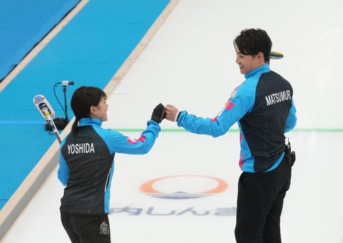竹田智子、竹田直将組との対戦の第5エンドを終え、笑顔でタッチを交わす吉田夕梨花(左)、松村雄太組(代表撮影)