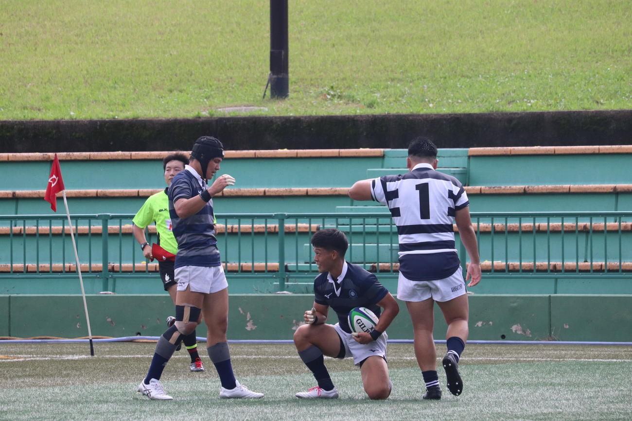 関大戦の前半、トライを決めて笑顔を見せる同大SH田村魁世（中央）（撮影・松本航）