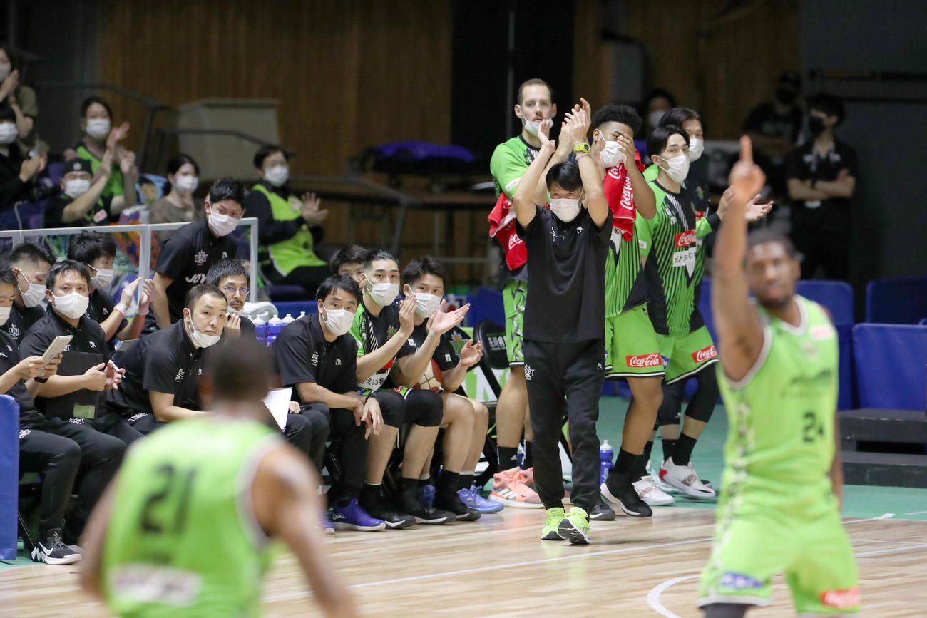 レバンガ北海道対三遠　第1Q、レバンガ北海道ブルックスの得点に拍手を送る佐古監督（中央）（撮影・佐藤翔太）