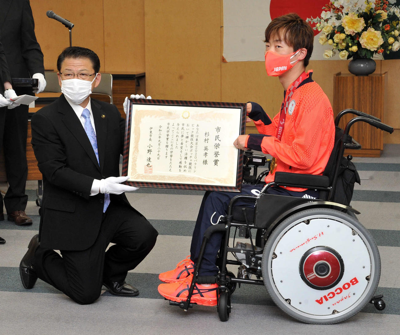 伊東市の小野市長（左）から市民栄誉賞の賞状を手渡される杉村
