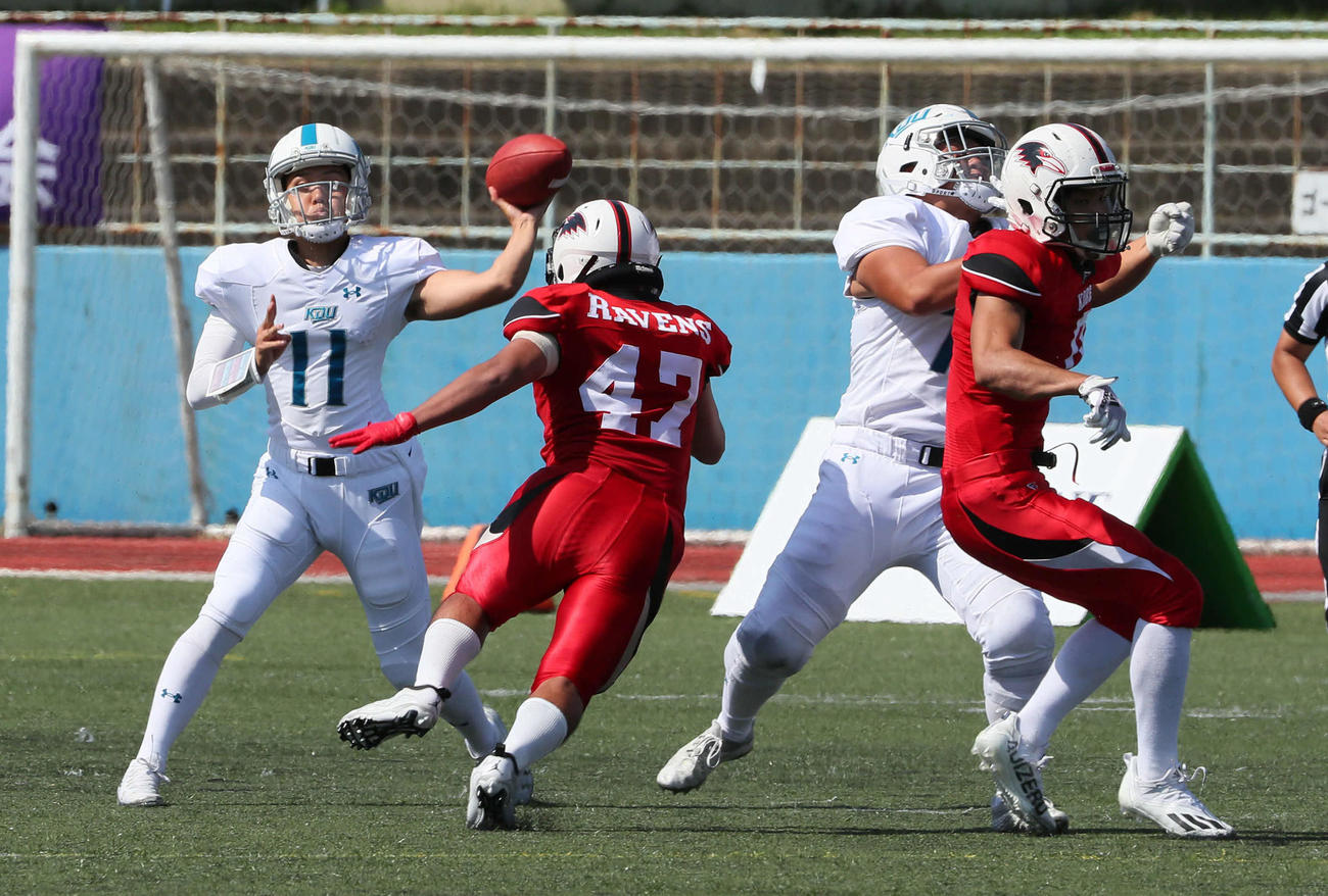 神戸大対近大戦　第3Q、近大QB中井琉来愛（左）はパスを通してファーストダウンを奪う（撮影・宮崎幸一）