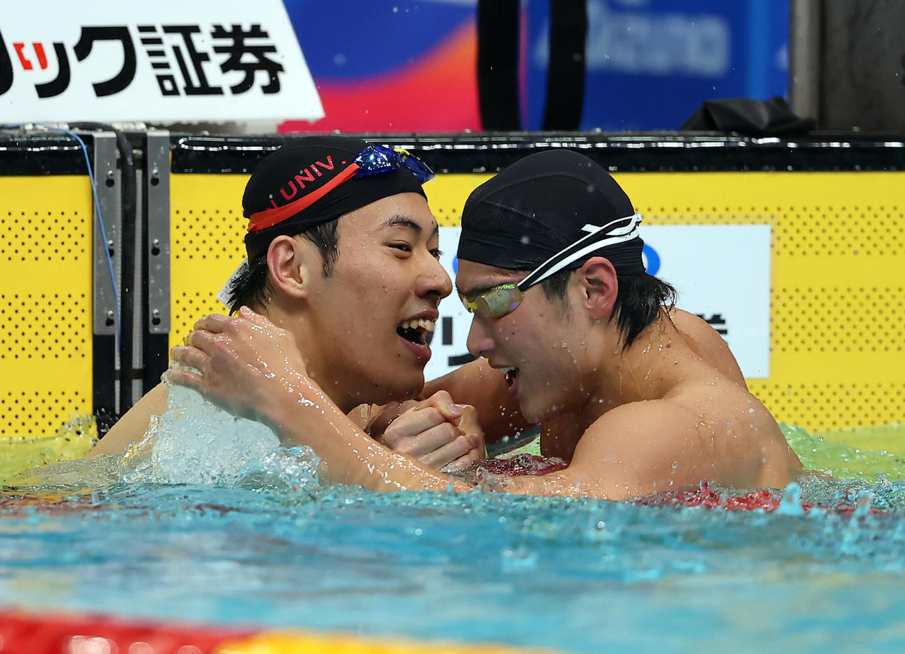 男子200メートルバタフライで優勝した本多（左）は、2位の田中と喜び合う（撮影・浅見桂子）