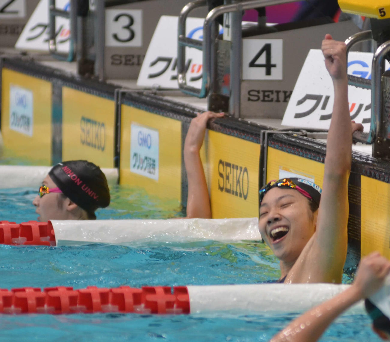 女子100メートルバタフライで初優勝して喜ぶ飯塚千遥。左は池江璃花子（撮影・吉池彰）