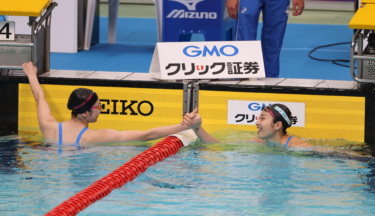女子100メートルバタフライ決勝、1着でゴールした飯塚（右）は2着の池江と握手を交わす（撮影・河野匠）