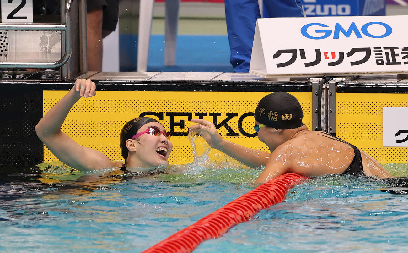 女子200メートル個人メドレー決勝、2分11秒43で優勝した松本（左）はチームメートの牧野と喜び合う（撮影・河野匠）