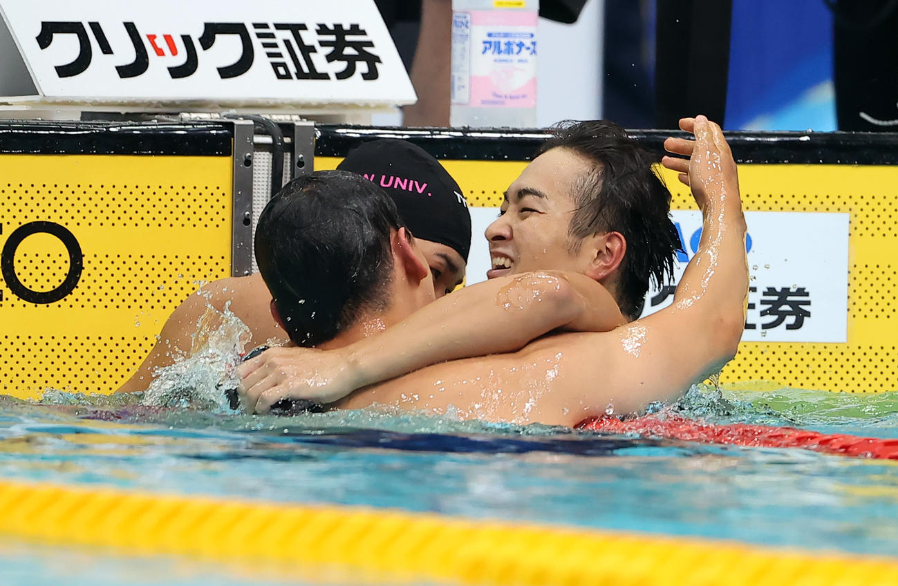 男子100メートル自由形を制した関（右）は、歓喜の抱擁をする（撮影・浅見桂子）