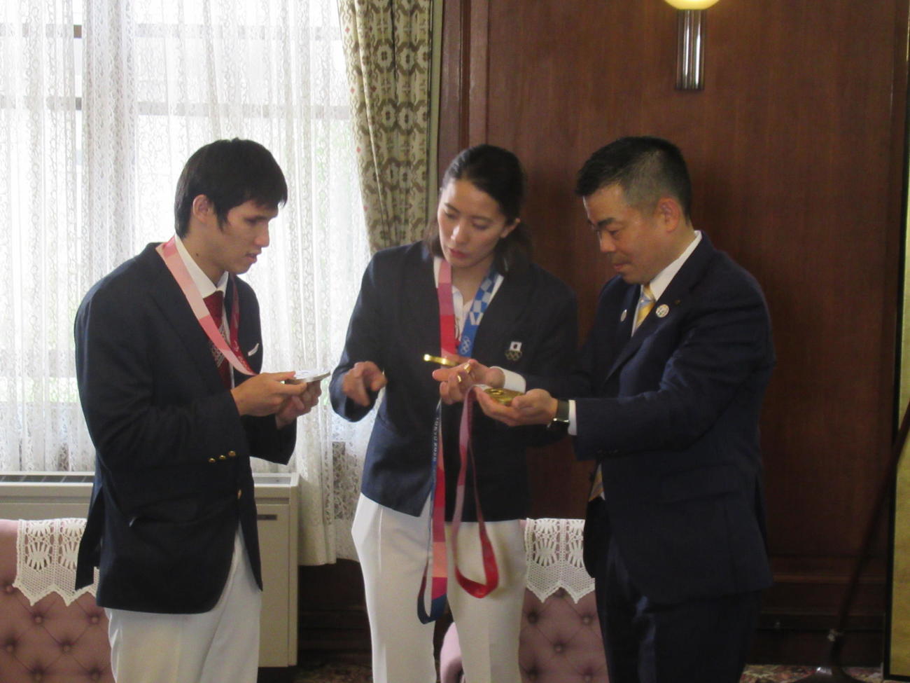 大橋悠依（中）と木村敬一（左）は、お互いの金メダルの違いを確かめた。右は三日月大造知事（撮影・益田一弘）