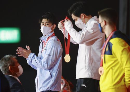 男子個人総合の表彰式で、優勝した張博恒(右から2人目)に拍手を送る2位の橋本(同3人目)