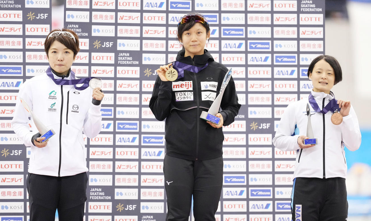 全日本スピードスケート距離別選手権大会　女子1000メートルで優勝し、メダルを手に記念写真に納まる高木美。左は2位の小平、右は3位の山田（撮影・菅敏）