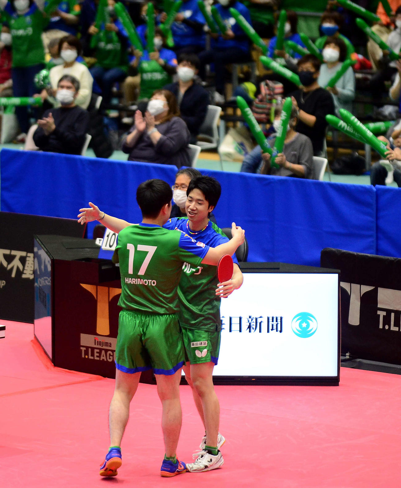勝利した水谷（手前右）は拍手の中、張本と抱き合う
