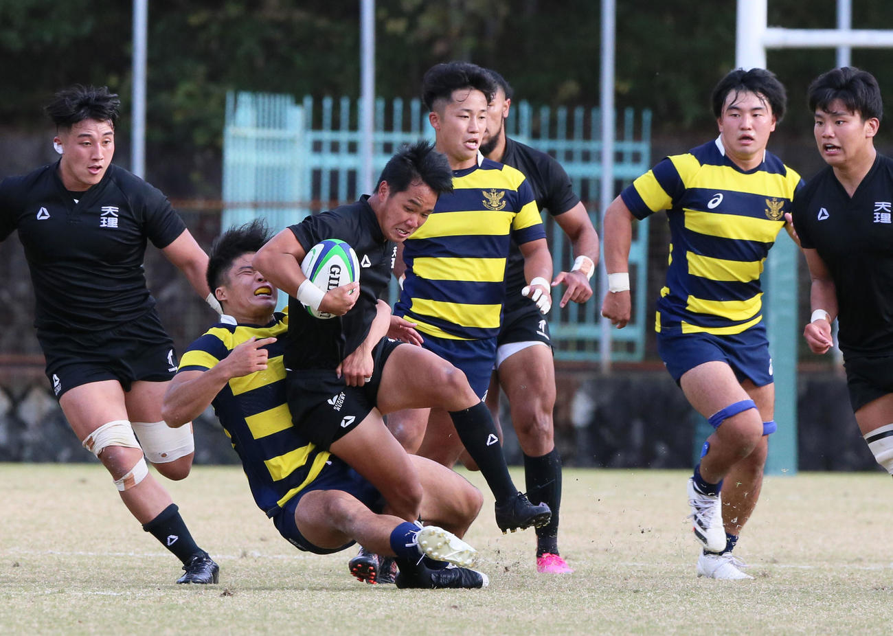 後半、タックルを受けながらも前進する天理FB江本（左から3人目）（撮影・上山淳一）