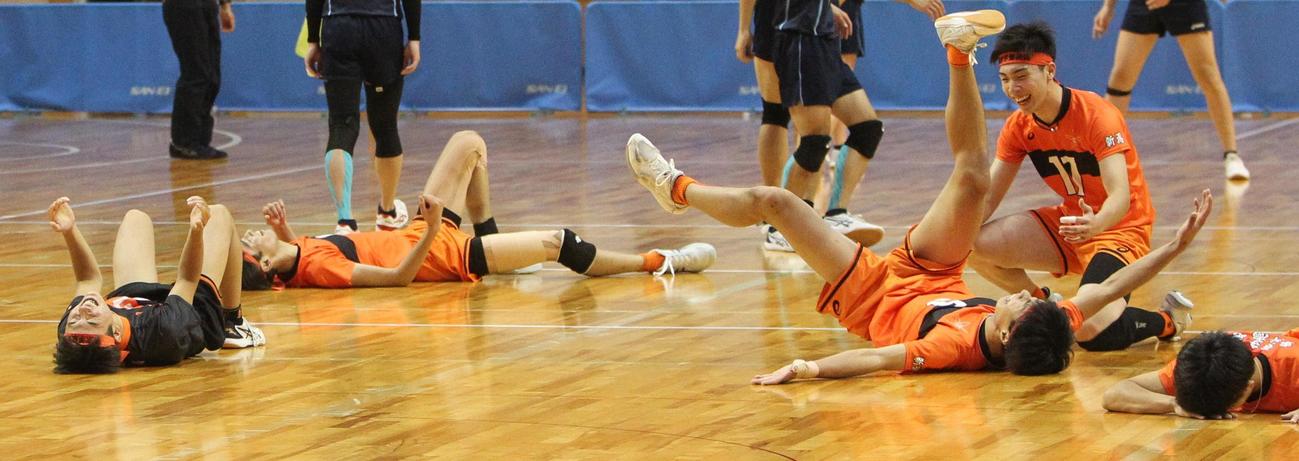 優勝を決め、コートに倒れ込む東京学館新潟の男子メンバー