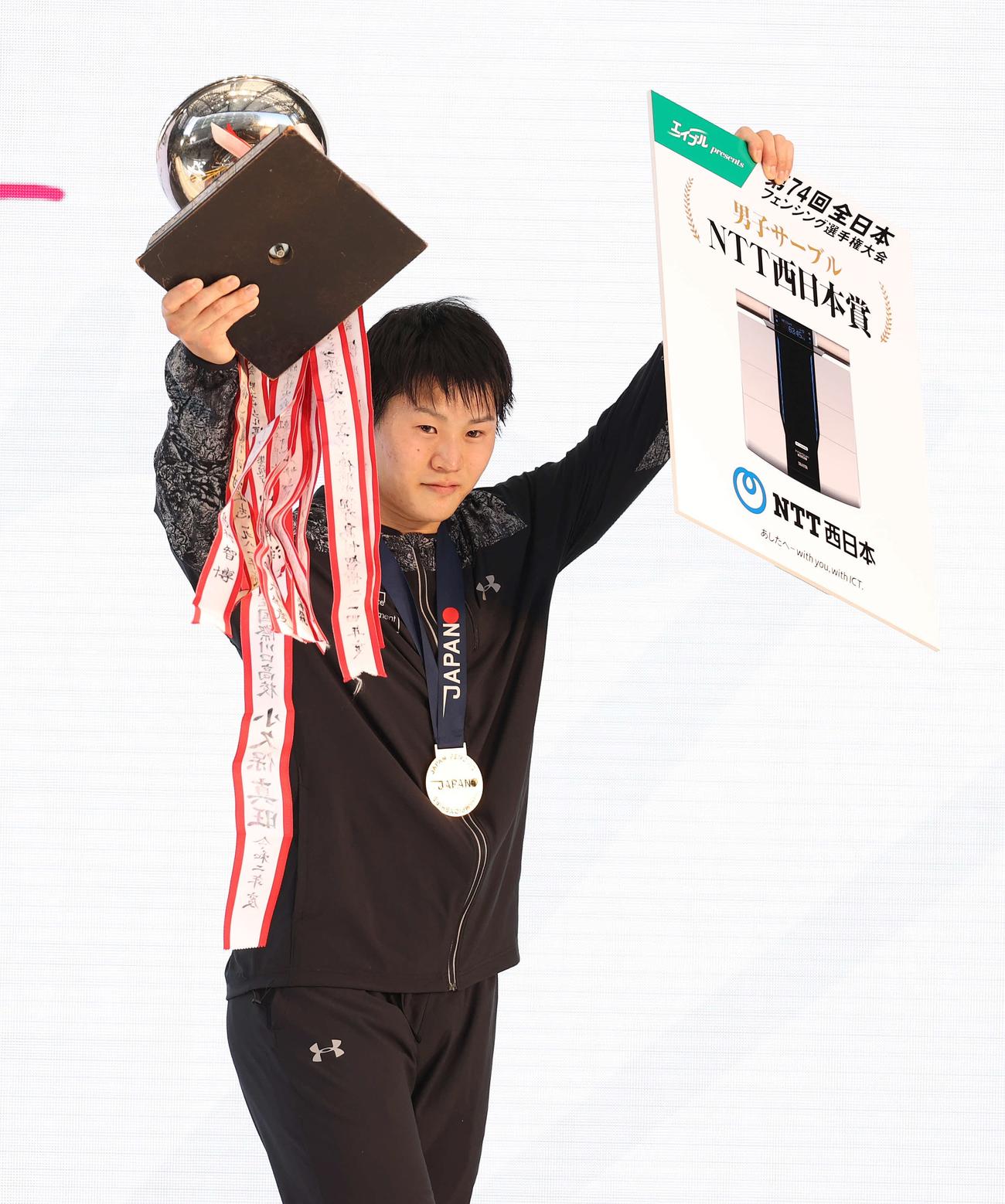男子サーブルで優勝し、カップを掲げる吉田健人（撮影・河野匠）
