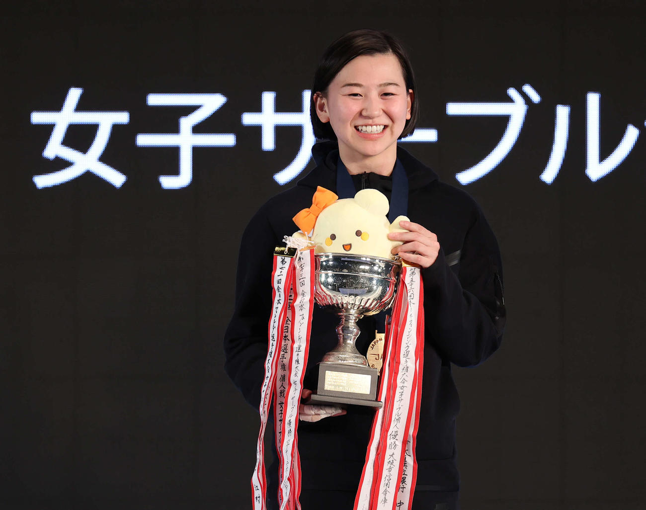 女子サーブルで優勝し、カップを手に笑顔を見せる高嶋（撮影・河野匠）