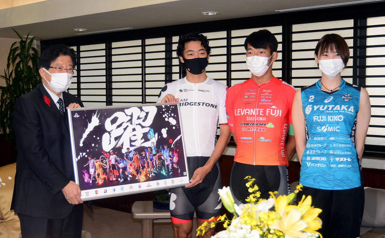 川勝知事（左端）に完成したポスターを披露する出席者。右からブレス浜松・中野、レバンテフジ静岡・佐野、チームブリヂストンサイクリング・河野