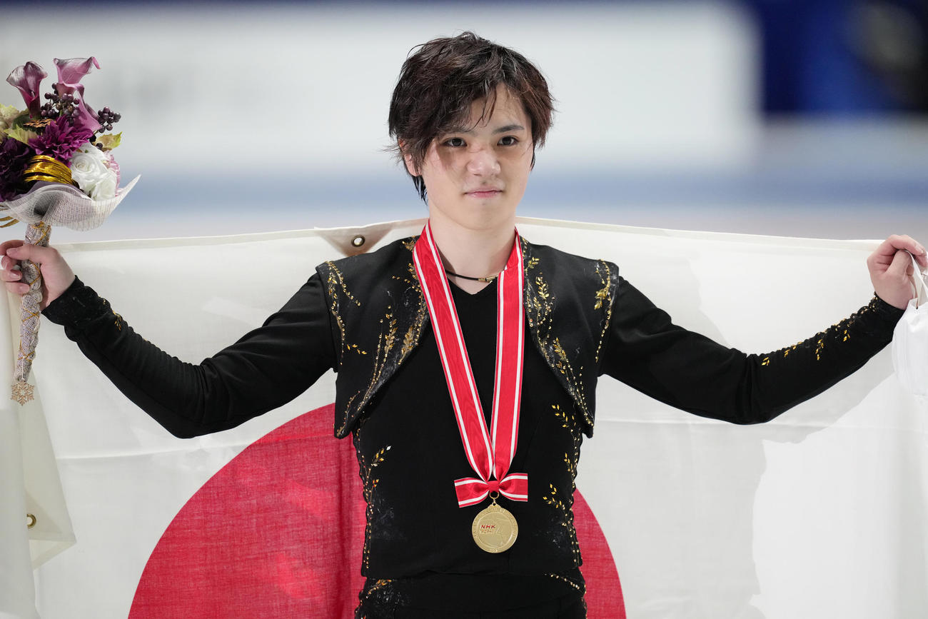 NHK杯男子で優勝し、メダルを胸に日の丸を掲げる宇野（撮影・菅敏）