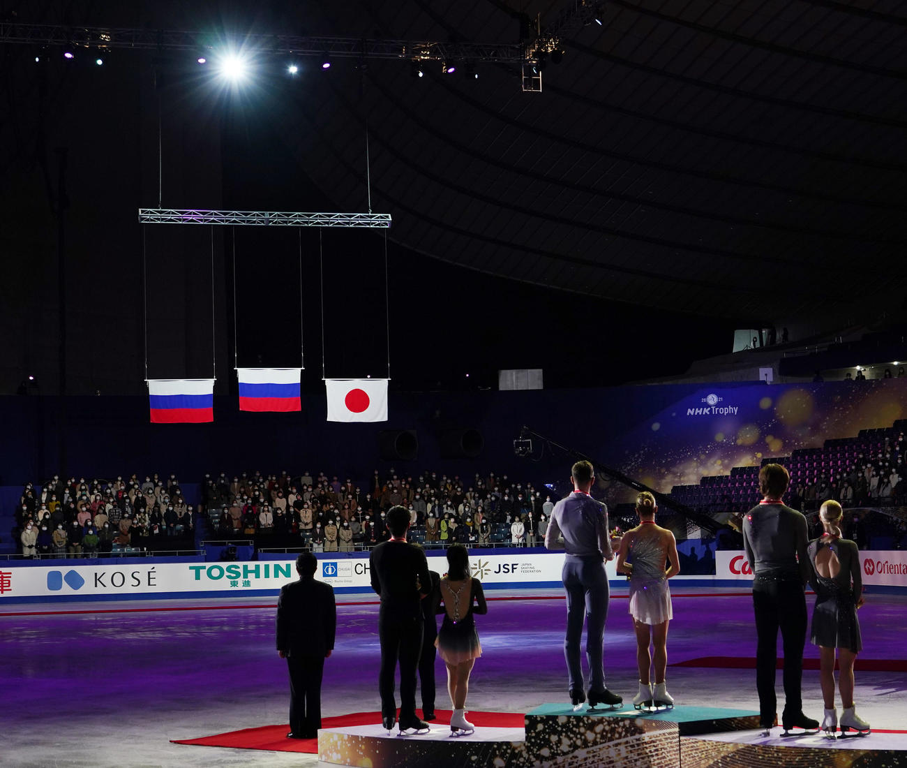 NHK杯ペアで3位に入り、表彰台から会場に上がる日の丸を見つめる三浦（左から3人目）と木原（左から2人目）（撮影・菅敏）