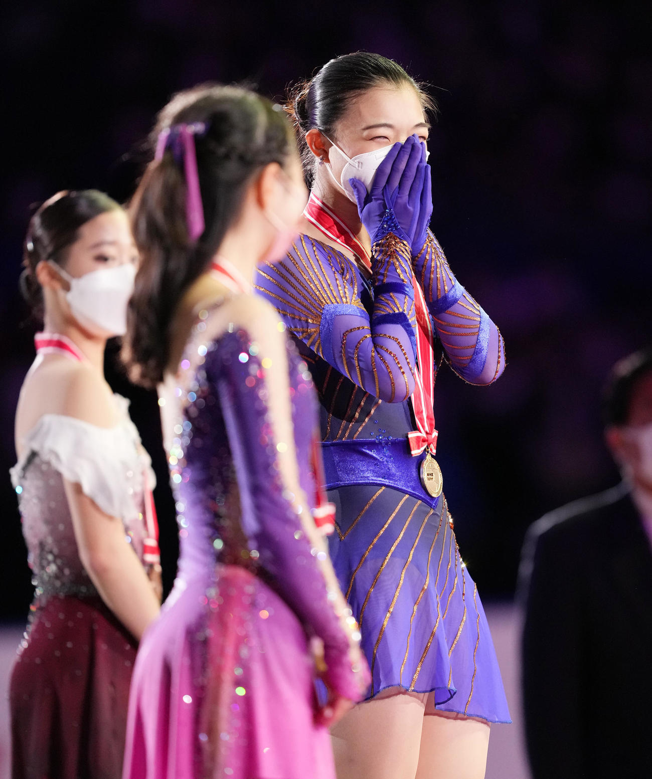 NHK杯女子で優勝し、表彰台の上で笑顔を見せる坂本。中央は2位河辺、左は3位ユ・ヨン（撮影・菅敏）