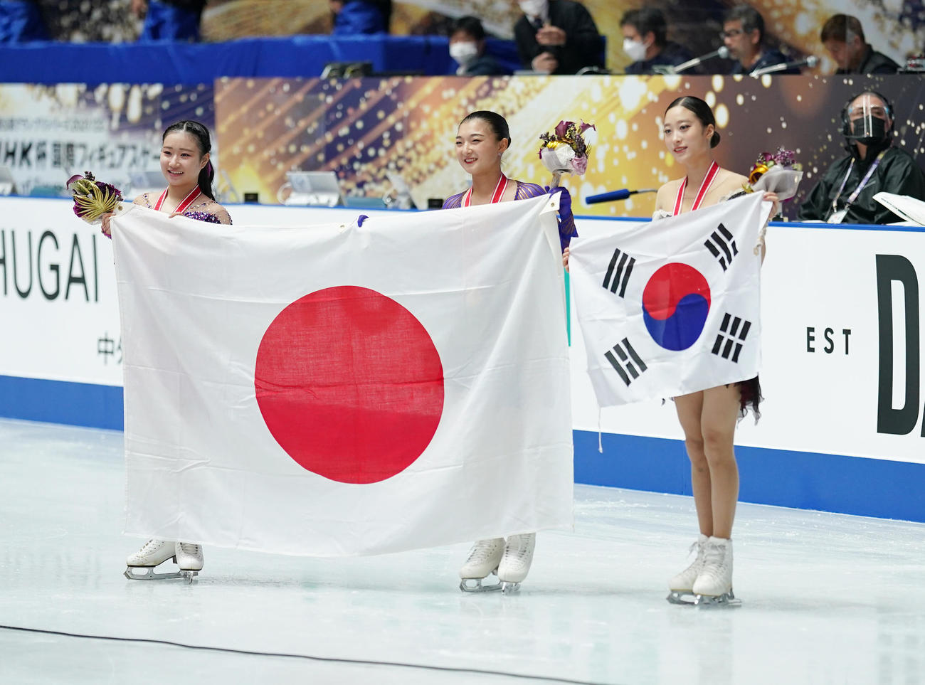 NHK杯女子で優勝し、メダルをかけ笑顔を見せる坂本。左は2位河辺、右は3位ユ・ヨン（撮影・菅敏）