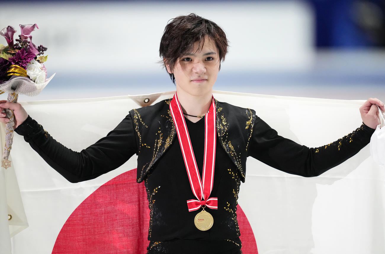 NHK杯男子で優勝し、メダルを胸に日の丸を掲げる宇野（撮影・菅敏）